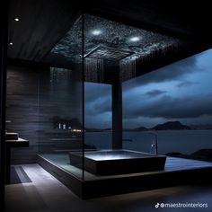 a bath room with a large tub next to a night time view and lights on the ceiling