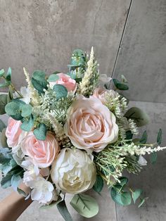 a bouquet of pink and white flowers sitting on top of a table