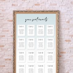 a wedding seating chart with the names and date on it in front of a brick wall