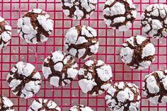 chocolate crinkle cookies with powdered sugar on a pink cooling rack, top view