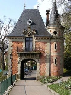 an old brick building with a clock tower on it's side and a walkway leading to the entrance