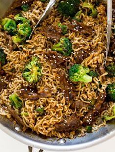 beef and broccoli stir fry in a wok with tongs