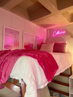 a bed with pink comforter and pillows in a room that is lit up by neon lights