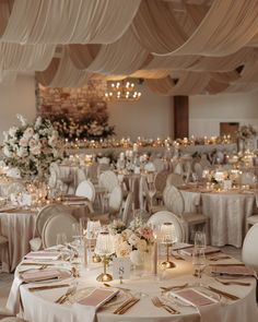 the tables are set with white linens and gold place settings for an elegant wedding reception