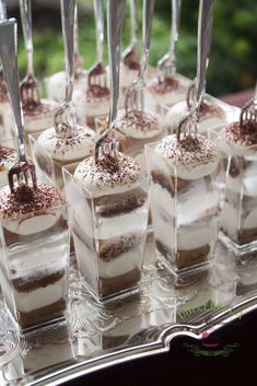 there are many desserts on the tray with forks stuck in each individual's cupcakes