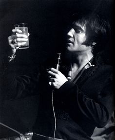 a man holding a glass in his right hand