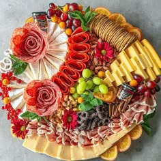 a platter filled with different types of cheeses and fruits on top of each other