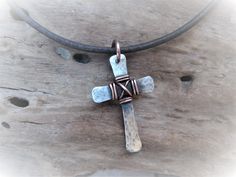 "This hammered solid mixed metal cross is a totally handmade piece of jewelry that can be for him or her! Sterling silver cross wire wrap around the center to add to its rustic look. A patina is added to the cross for a vintage weathered look. As a final touch, the cross is polished and sealed to avoid natural oxidation process. It measures about 1.3 inches x 0.9 inches / 3.2 cm x 2.2 cm. The pendant is hung on a 1/8\" / 2.5 mm genuine leather cord featuring a secure handmade hook fastener in co Handmade Adjustable Cross Pendant Necklace, Artisan Adjustable Cross Jewelry, Adjustable Metal Cross Necklace, Handmade Adjustable Crucifix Cross Necklace, Artisan Hand Forged Cross Jewelry, Handmade Adjustable Cross Necklace, Blue Sea Glass Necklace, Wire Wrapped Crystal Pendant, Mens Bracelet Black