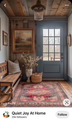 a blue front door with an area rug on the floor and a wooden bench next to it