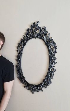 a man standing in front of a wall with a mirror on it's side