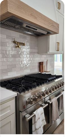 a stove top oven sitting inside of a kitchen next to an oven with two burners