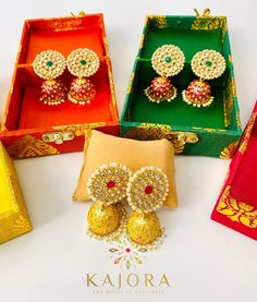 four different colored boxes with earrings in them