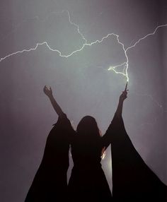 two women standing in front of a lightning storm