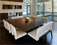 a dining room table surrounded by white chairs