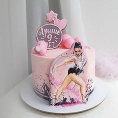 a pink and black cake with an image of a woman on it