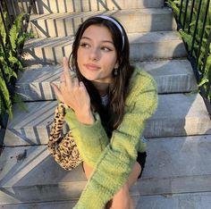 a woman sitting on the steps with her hand up