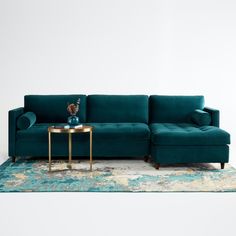 a blue couch sitting on top of a rug next to a table