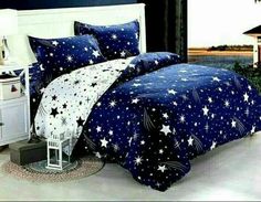 a bed room with a neatly made bed and night sky comforter set on it