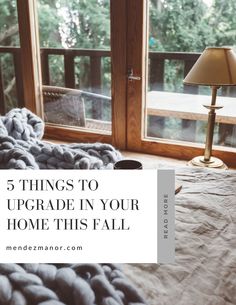 a bed with a blanket on top of it in front of a window and the words, 5 things to upgrade in your home this fall