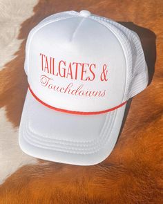 Get ready for game day with the "Tailgates & Touchdowns" trucker hat--a must-have for every fan. Designed with breathable mesh and a comfortable snapback fit, this hat is perfect for long days at the tailgate and cheering in the stands. The bold lettering on the front lets everyone know your priorities: great times and great football. Whether you're rooting for your favorite team or just soaking up the atmosphere, this trucker hat is the ultimate accessory for any football enthusiast. Bold Lettering, Red Rope, White Hat, Everyone Knows, Austin Tx, Trucker Cap, Favorite Team, Game Day, Caps Hats