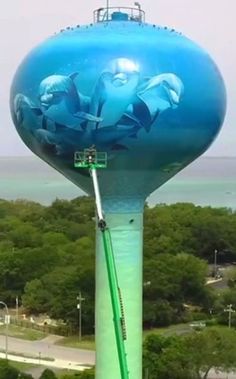 a large blue water tower with dolphins painted on it