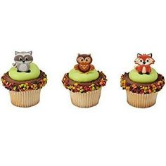 three cupcakes with green frosting and an owl on the top one is decorated with leaves