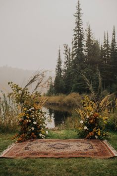 an outdoor ceremony setup with flowers and greenery