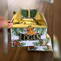 someone is holding up a box that has the name logan on it and an image of lion