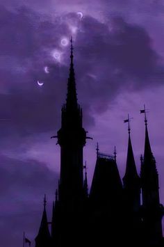 the silhouette of a castle against a purple sky with moon and stars in the background