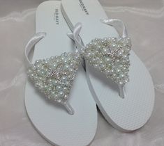 These beautiful white flip flops are wrapped with white satin ribbon, and I have threaded by hand small, medium and large white pearls, clear crystal and silver seed beads  all in the front and place a silver starfish on the middle. Ribbon color is white, if you are needing other colors of ribbon or decoration please contact me and will be happy to accommodate you! All flip flops are handmade to order and the production time is 5-7 business days and then please allow additional time for shipping Boho Wedding Shoes, Bridal Flip Flops, Custom Wedding Shoes, Beach Wedding Sandals, Wedding Flip Flops, Sandals Wedding, White Flip Flops, Sandals Beach, Bridal Sandals