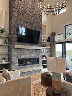 a living room with couches, chairs and a television mounted on the wall in front of a fireplace