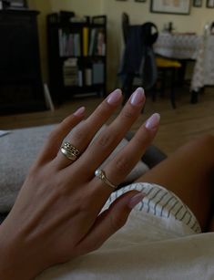 a woman's hand with two gold rings on her left and one in the middle