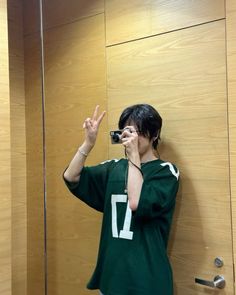 a woman taking a selfie in front of a mirror with her cell phone up to her ear