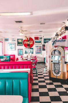 the interior of a diner with checkered flooring and colorful booths on either side