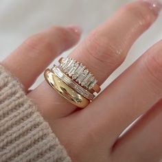 a woman's hand with two different rings on it and one is wearing a sweater