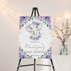 a welcome sign with an elephant and purple flowers is displayed in front of a white backdrop