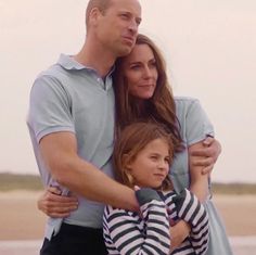 a man and woman hugging each other on the beach