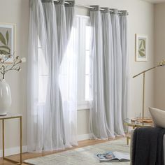 a living room filled with furniture and white curtains