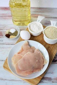 ingredients for cooking chicken sit on a cutting board