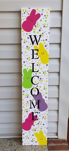 a welcome sign is painted on the side of a house in front of a door