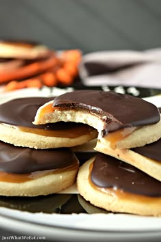 chocolate covered cookies on a plate with carrots in the background