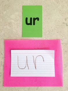 a piece of paper with the word u in it next to a green and white sign