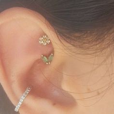 a woman's ear with three small flowers attached to the back of her ear