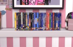 a shelf filled with lots of books on top of a pink and white striped wall