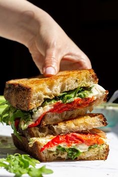 a person is holding a sandwich in their hand while they are preparing to eat it