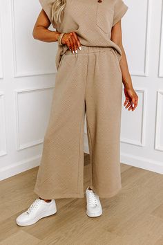 - These casual-chic pants are a must-have! Their stylish design and relaxed fit make it perfect for elevating your everyday wardrobe. Achieve a luxe look with this fabulous piece! - Unlined material with a trendy texture - An elastic waistband - Functional side pockets - A wide legged silhouette that ends in straight hemlines