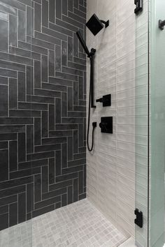 a walk in shower sitting next to a tiled wall