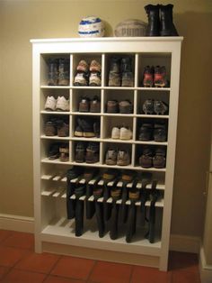 a white bookcase filled with lots of boots and booties on top of it