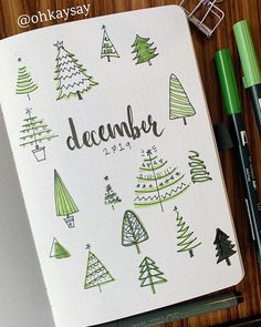 a notebook with christmas trees and the word december written on it next to some pens