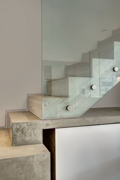 a staircase with glass balustrades and white walls